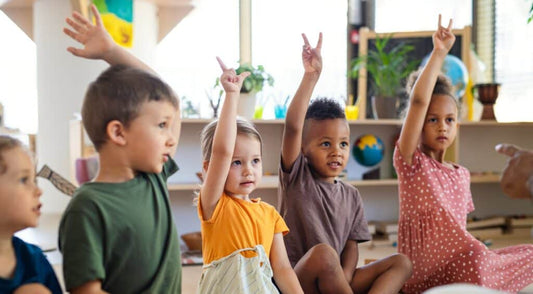 kids sitting and raising their hands to answer something